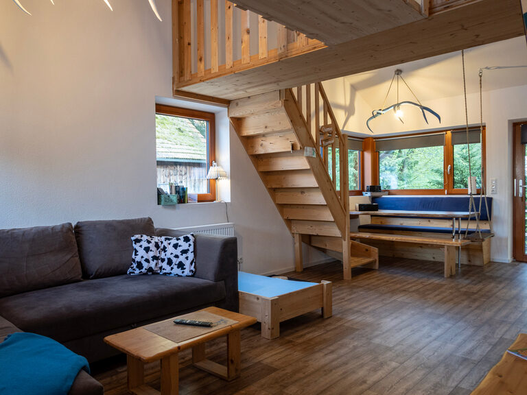 Das Wohnzimmer der Ferienwohnung Maxx mit modernen Holzmöbeln.