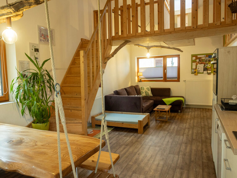Wohnbereich mit Sofa, Tisch, Küche, Treppe in 2. Stock in Ferienwohnung